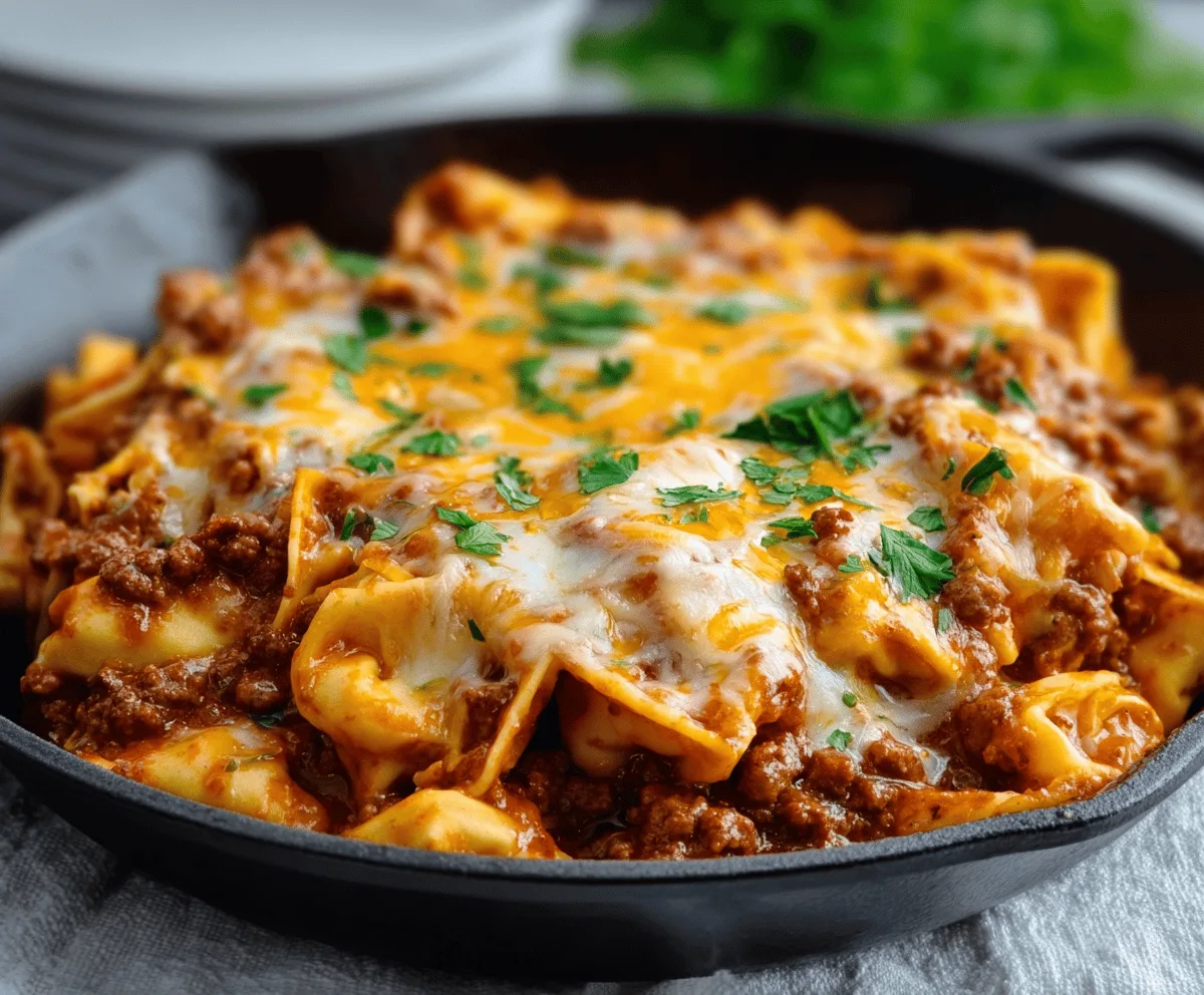 Plate of cheesy beef enchiladas tortellini featuring melted cheese and savory beef in a flavorful sauce.
